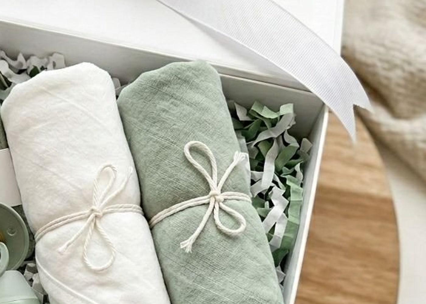 The lid off the box, the ribbon loose, everything rolled and tied in paper