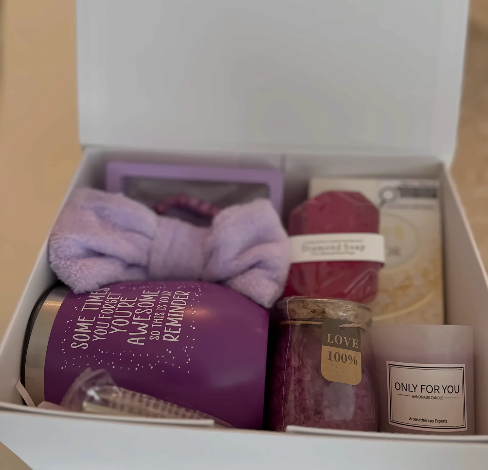 A white employee gift box open on a table, everything set in place