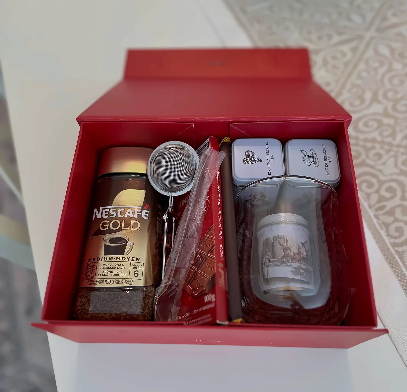 A red employee gift box open on a table, with a divider down the middle