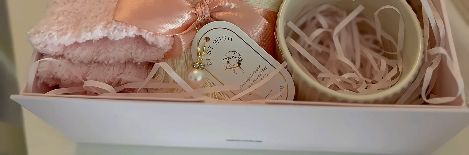 The front of the pink box, pink paper shred and something soft set in it